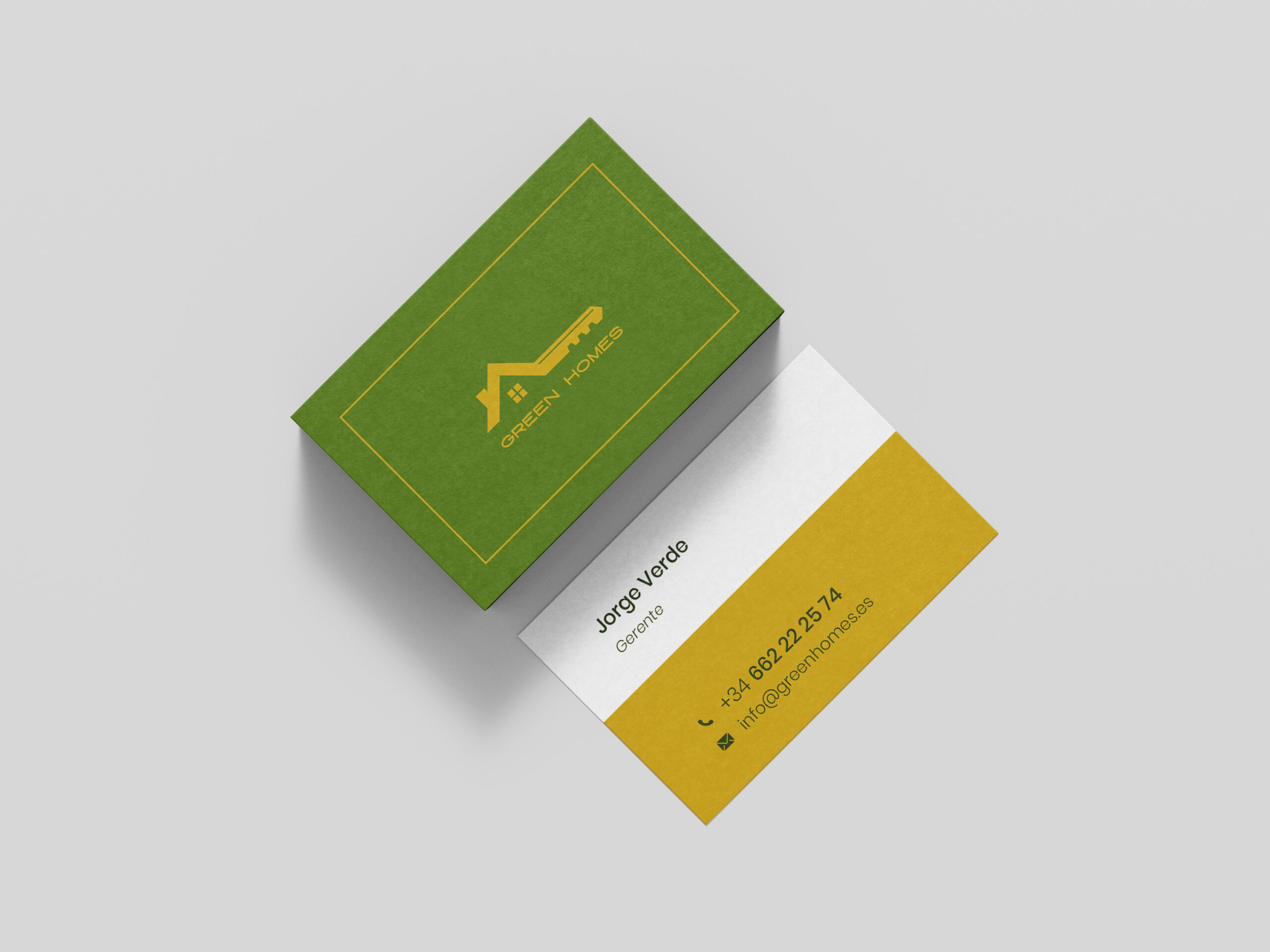 Tarjetas de visita Green Homes con diseño corporativo en verde y amarillo sobre fondo neutro.